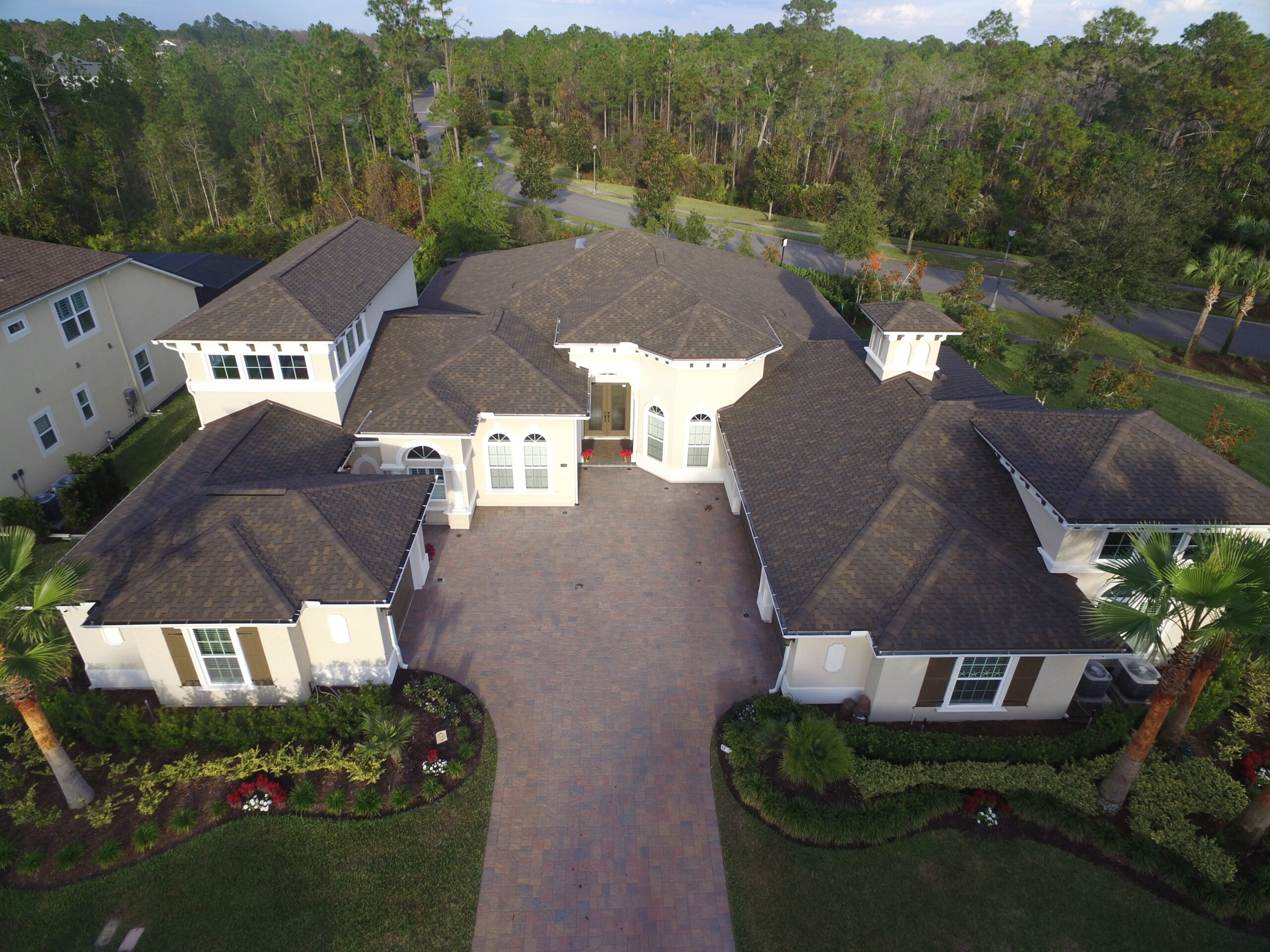 Large dark shingle roof white home