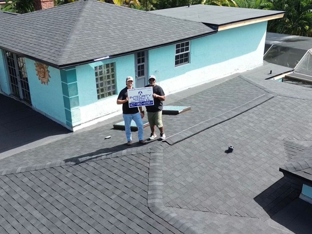 user-inserted Roofing contractors from Integrity Roofing standing on a newly installed asphalt shingle roof during inspection.