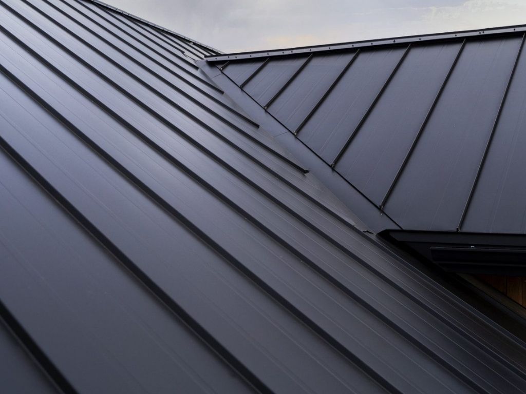 Close-up of a black standing seam metal roof, showcasing sleek, durable panels and precise detailing, ideal for modern homes seeking longevity and aesthetic appeal.