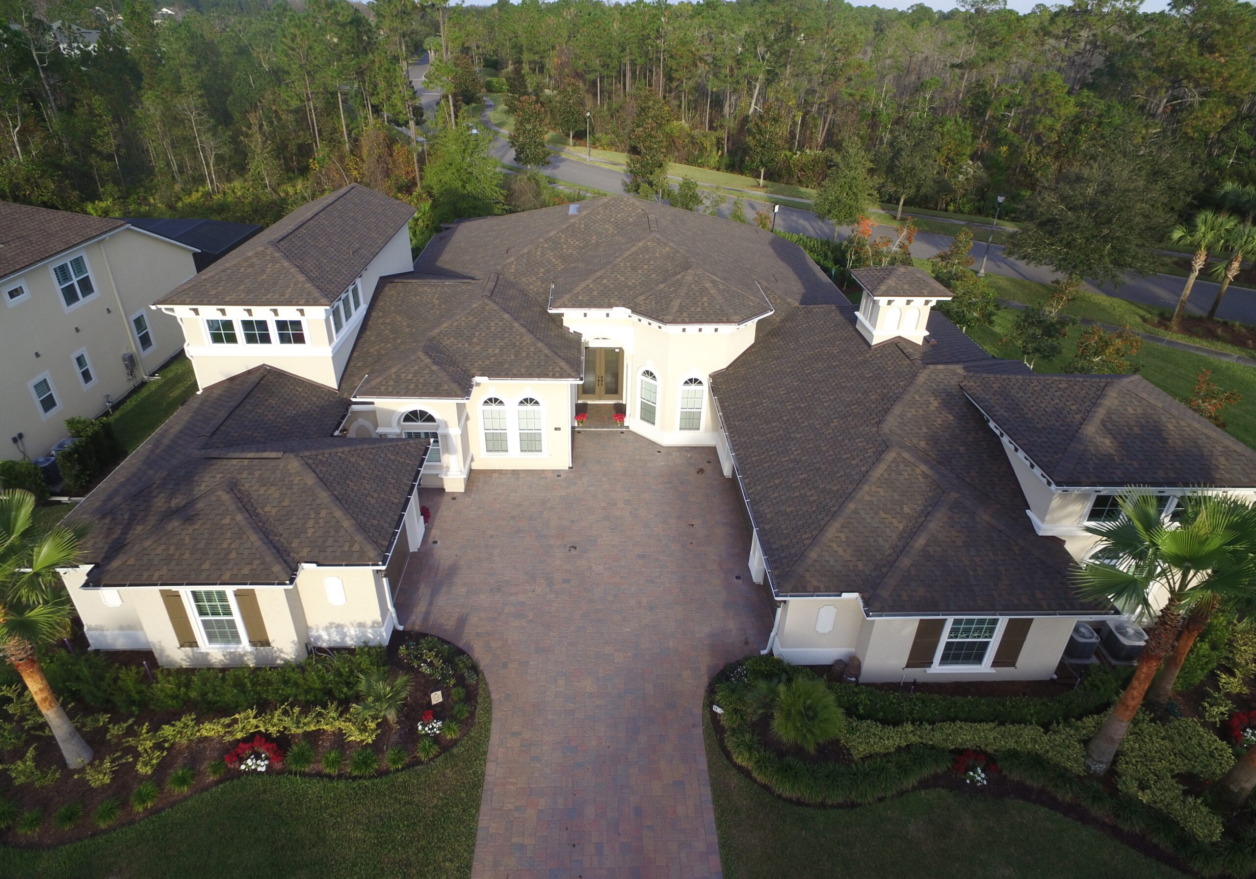 Large dark shingle roof white home