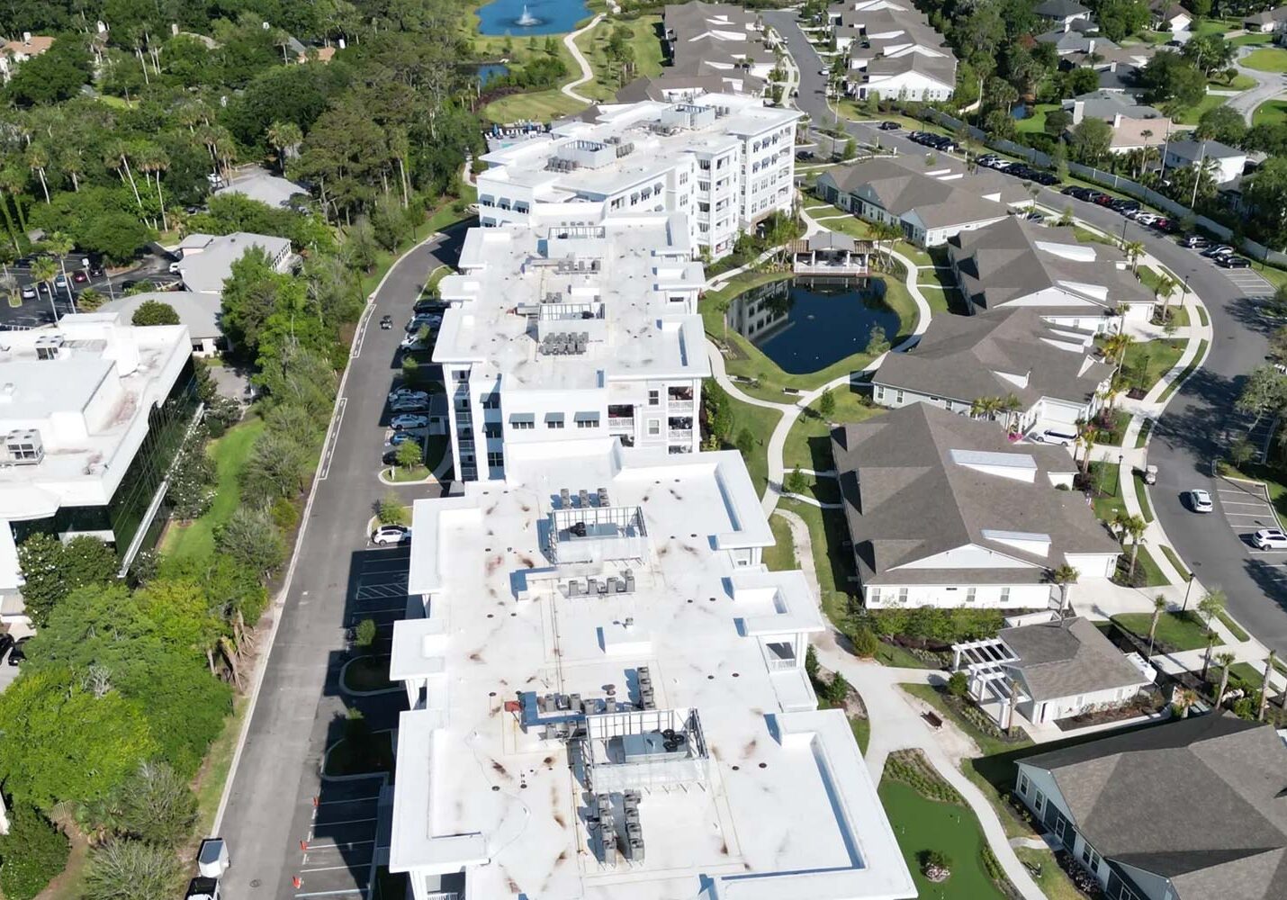 High‑angle shot showing multiple interconnected commercial flat roofs with HVAC systems
